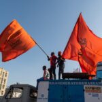 Deux hommes agitant des drapeaux de safran sur un véhicule lors d’un rassemblement de l’Hindutva © balajisrinivasan/Shutterstock