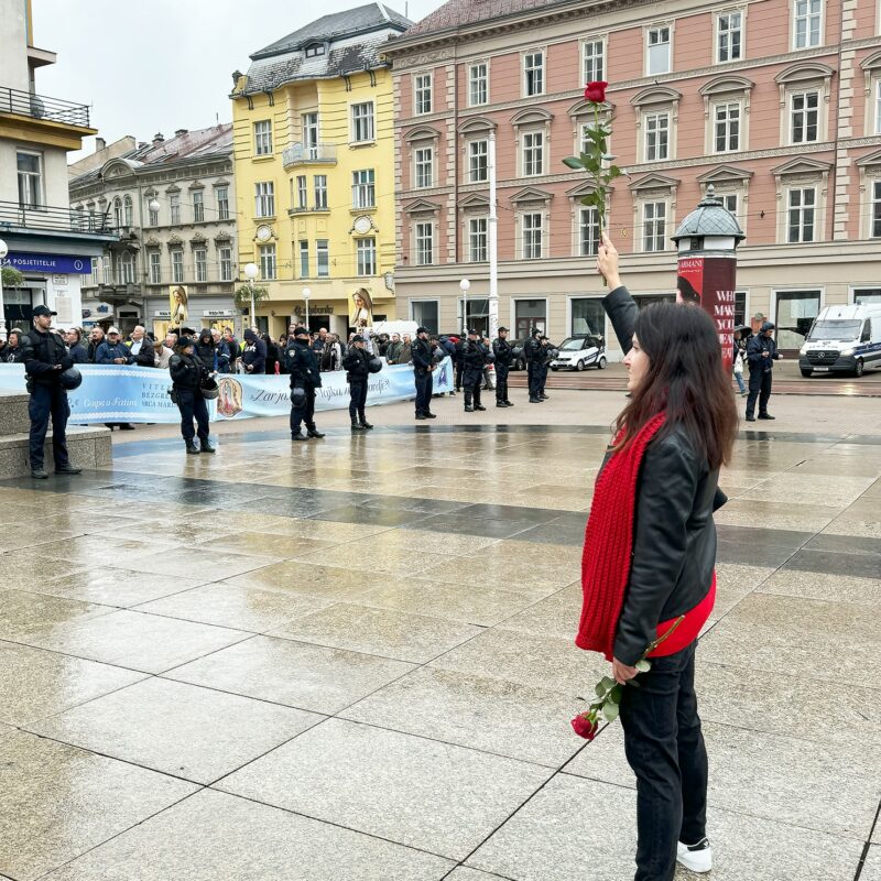 L’artiviste Arijana Lekić-Fridrih tente de résister aux agenouillés une rose à la main. © Sandra Evrard