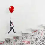 Businessman,In,A,Suit,Flying,Happily,Holding,A,Balloon,Over